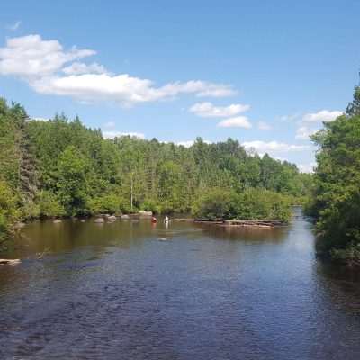 Hot summer day makes the Pine river run low enough you can bring a chair out and sit in the river like these folks.