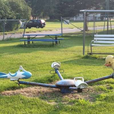 Duck and space ship and a couple of saddles on this old playground spinning ride toy.