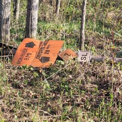 State Line Trail sign down. It is 8 Miles to Iron River and 20 Miles to Crystal falls from this sign.