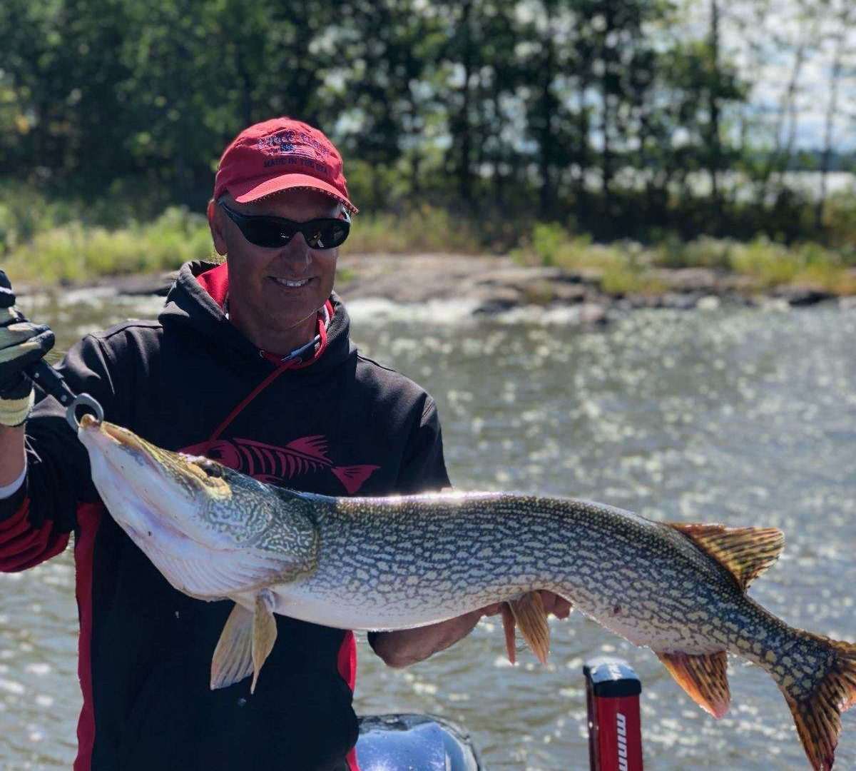 Man holding a large fish on a boat.