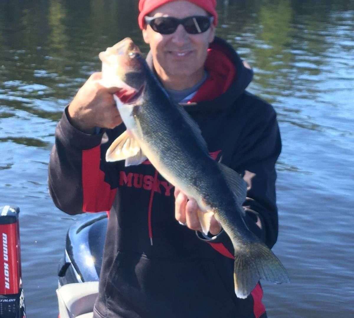 Man holding large fish on a boat.