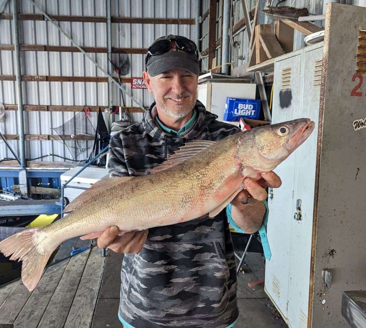 Man holding large fish in a warehouse