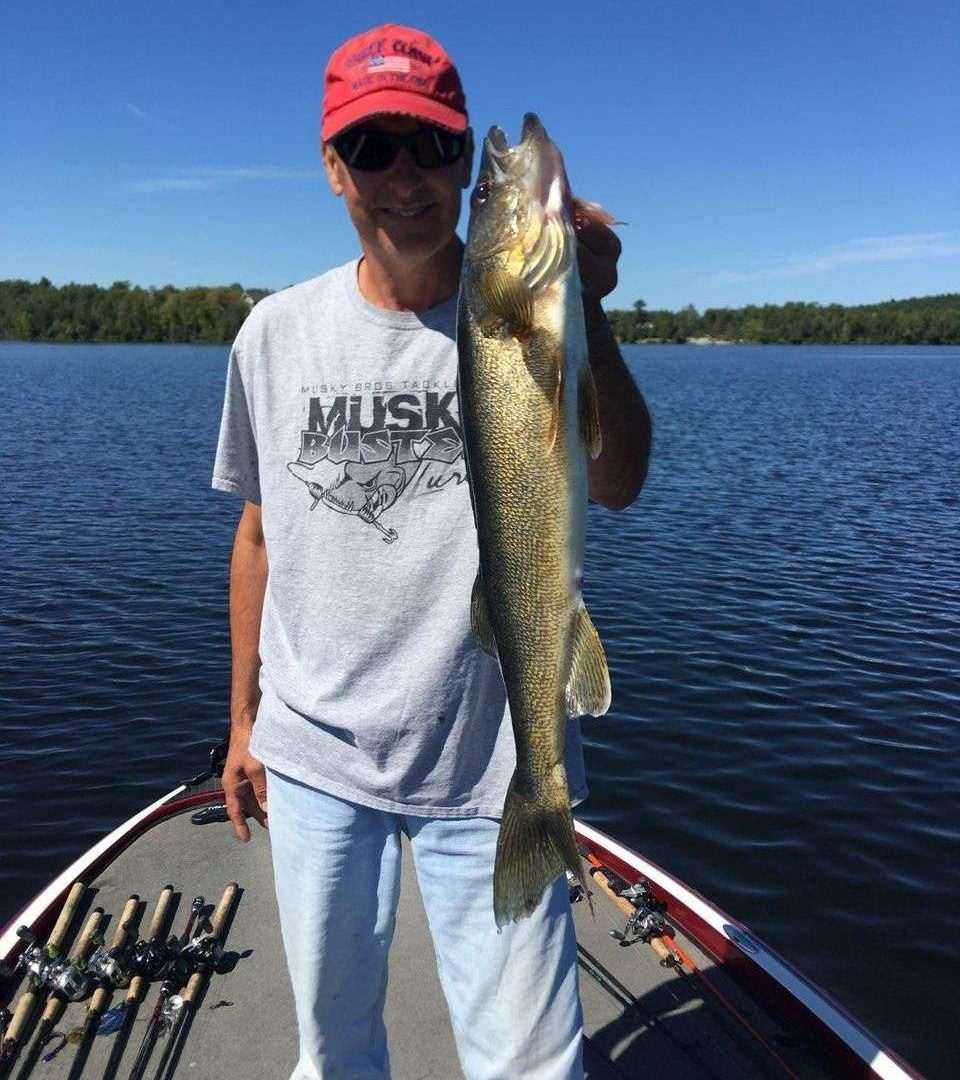 Man holding large fish on a boat.