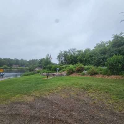 Boat landing with Clarks Landing sign by river.