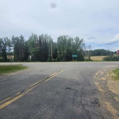 Rural road intersection with stop sign and trees