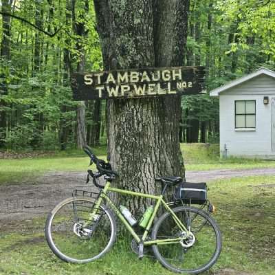 Bicycle by tree and sign in forest