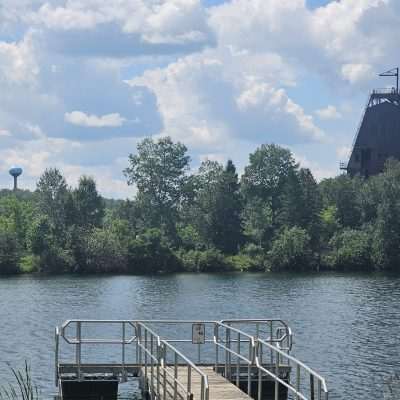 Dock with lake and trees on a sunny day.