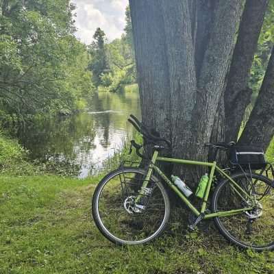 Green bike by tree near lake