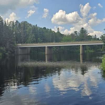 Bridge over a calm river with trees