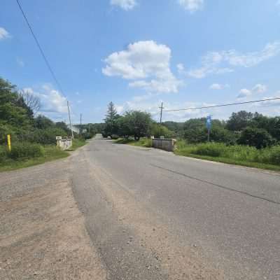 Rural road with trees and power lines.