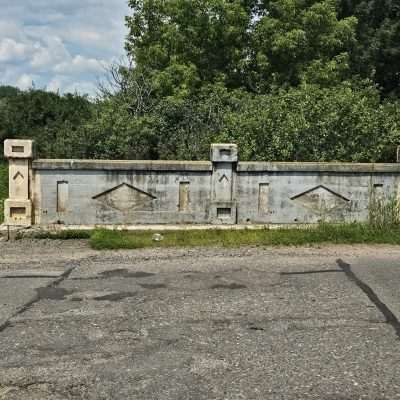 Old concrete bridge railing in rural area.