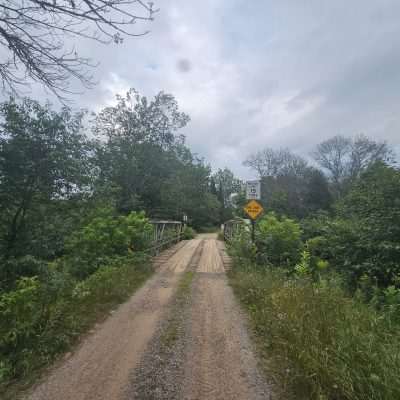 One-lane wooden bridge in dense greenery