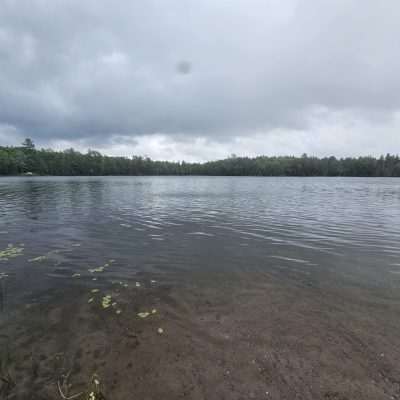 Calm lake with cloudy sky in background