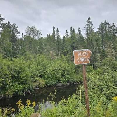 Bush Creek sign near forest and creek U.P. Michigan.