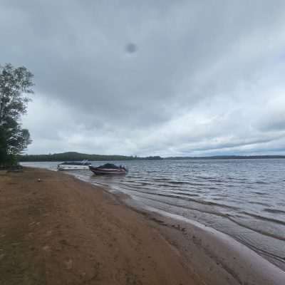 Cloudy lakeside view with boats on sandy shore of the Michigamme Reservoir at the WE Energies Campground.