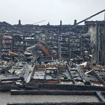 Burnt building with damaged interior and shelves.