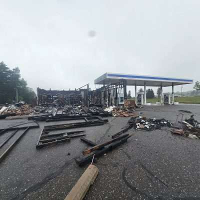 Burned down gas station, debris scattered everywhere.