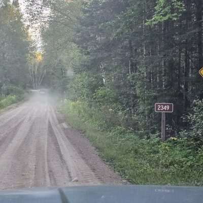 Dirt road with curve sign and 2349 mile marker