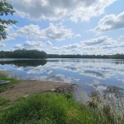 Serene lake with fishing poles and clear sky