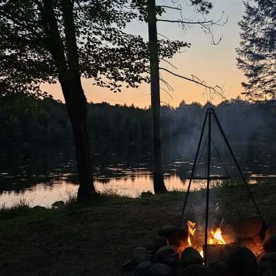 Campfire by lake at sunset on Camp Three Lake in Northern Wisconsin.