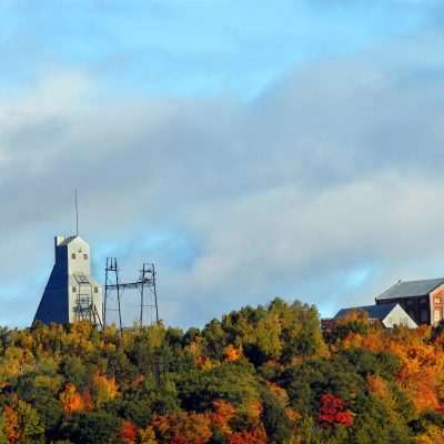 Old mine buildings in colorful autumn forest.