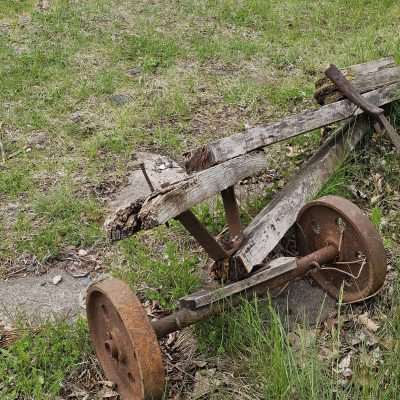 Rustic wooden farm equipment with rusty wheels